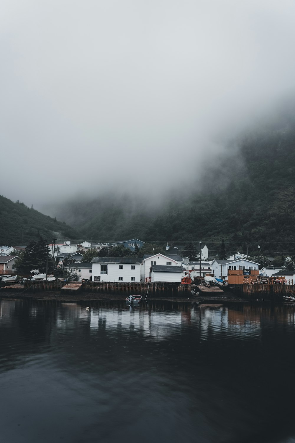 a body of water with houses on a hill in the background