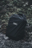 A collection of rugged military-style backpacks arranged outdoors on a rock surface.