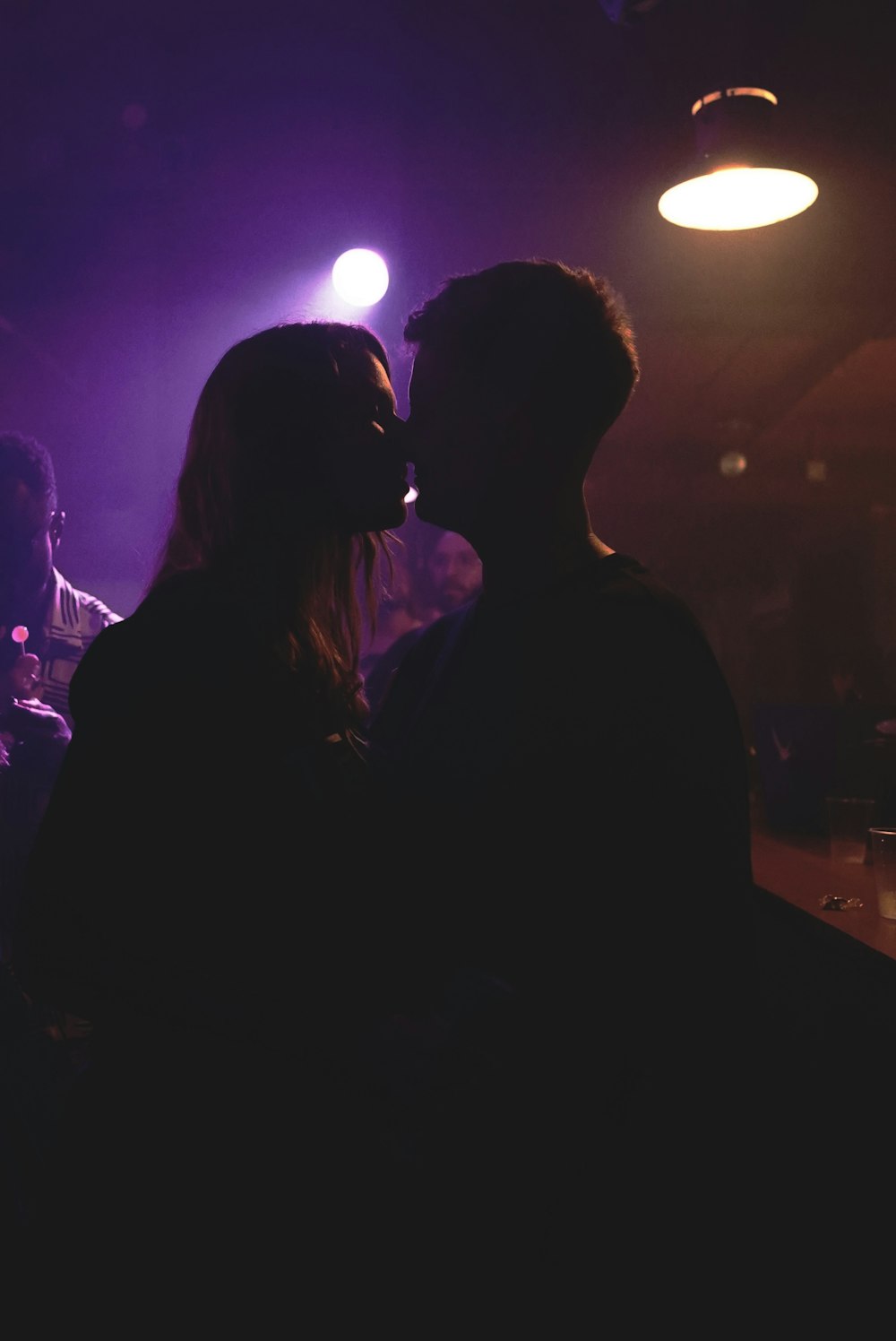 a man and a woman kissing in a dark room