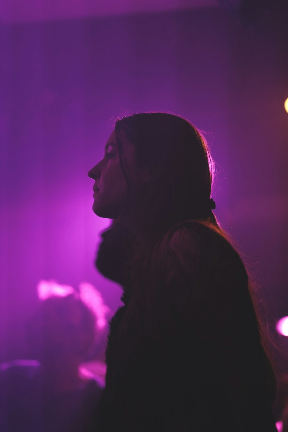 a woman standing in front of a purple light