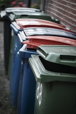 a row of trash cans sitting next to a brick wall