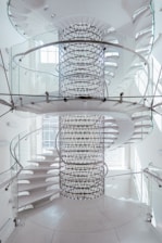 a spiral staircase in a white building with glass railings