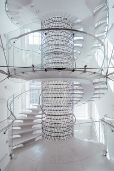 a spiral staircase in a white building with glass railings
