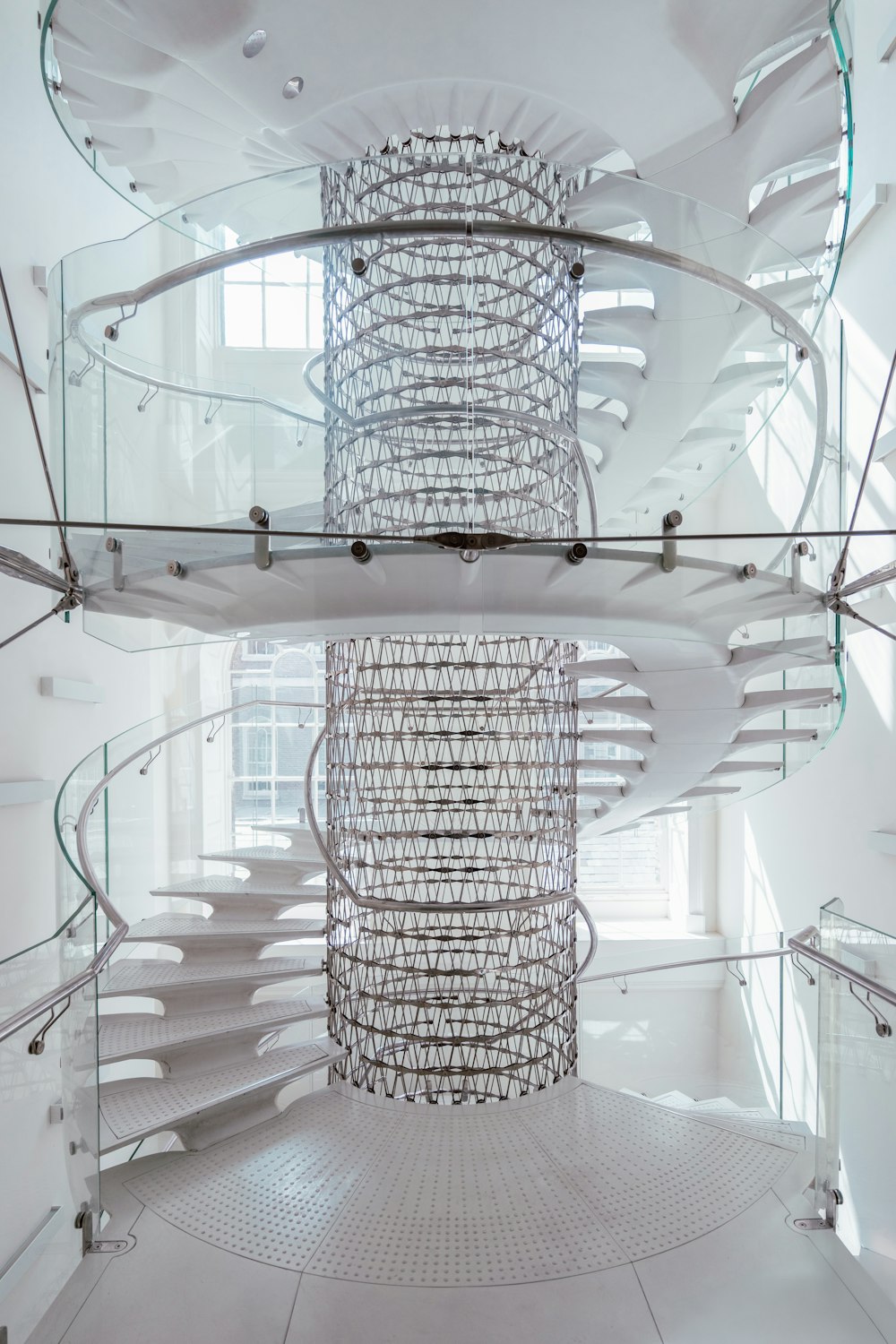 a spiral staircase in a white building with glass railings