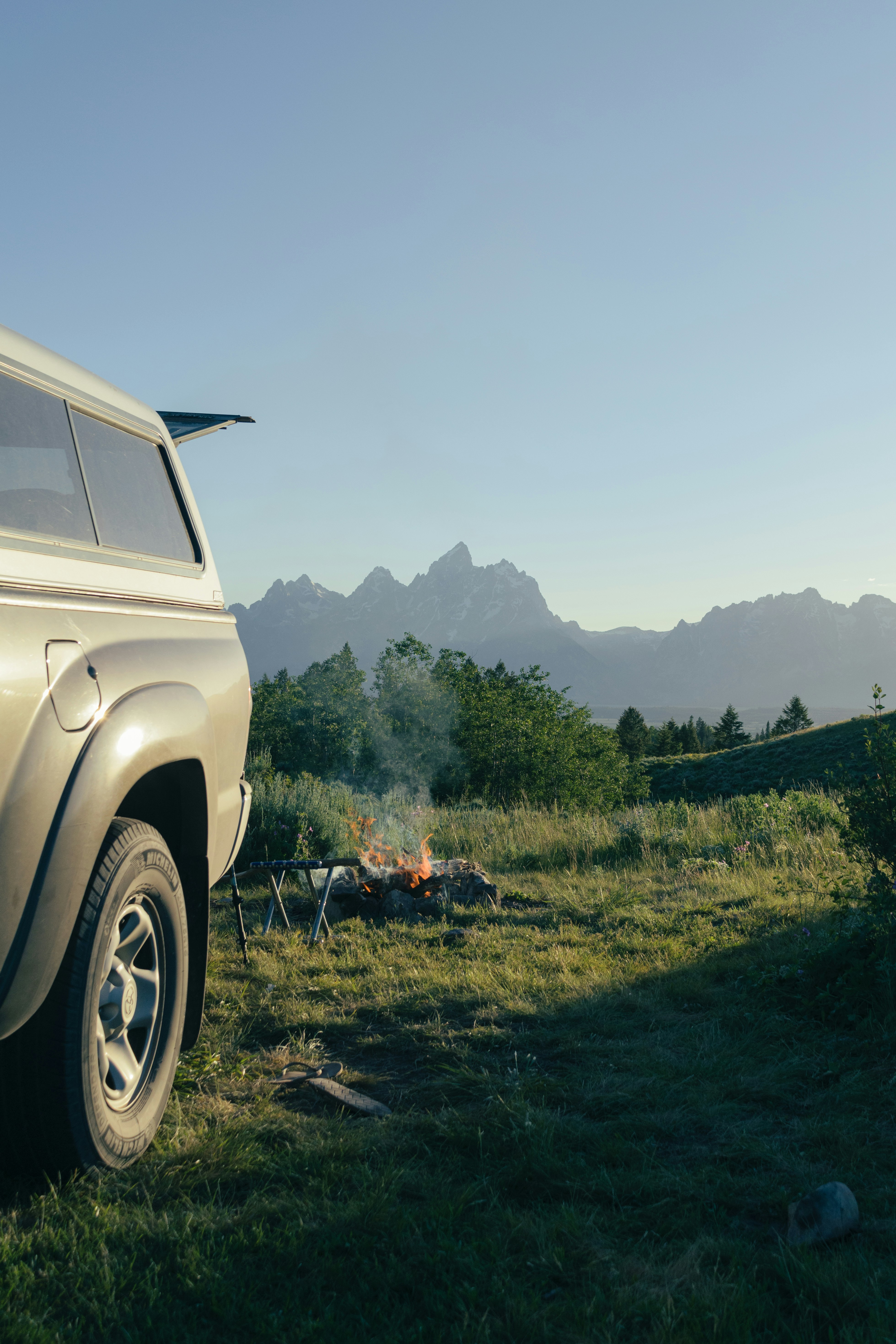 White RV camper van parked in scenic mountain landscape, adventure travel, golden hour light