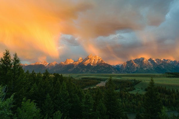 Evening light breaking through storm clouds over the Teton Range above Jackson Hole
