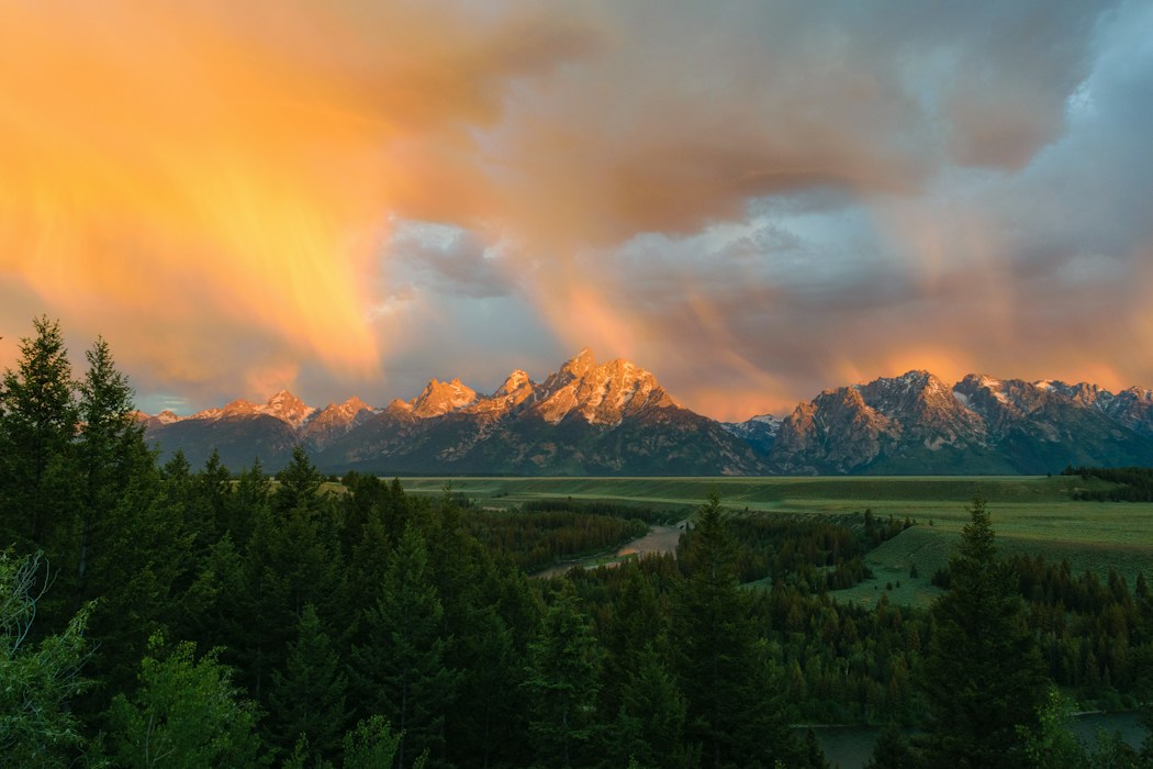 Evening light breaking through storm clouds over the Teton Range above Jackson Hole