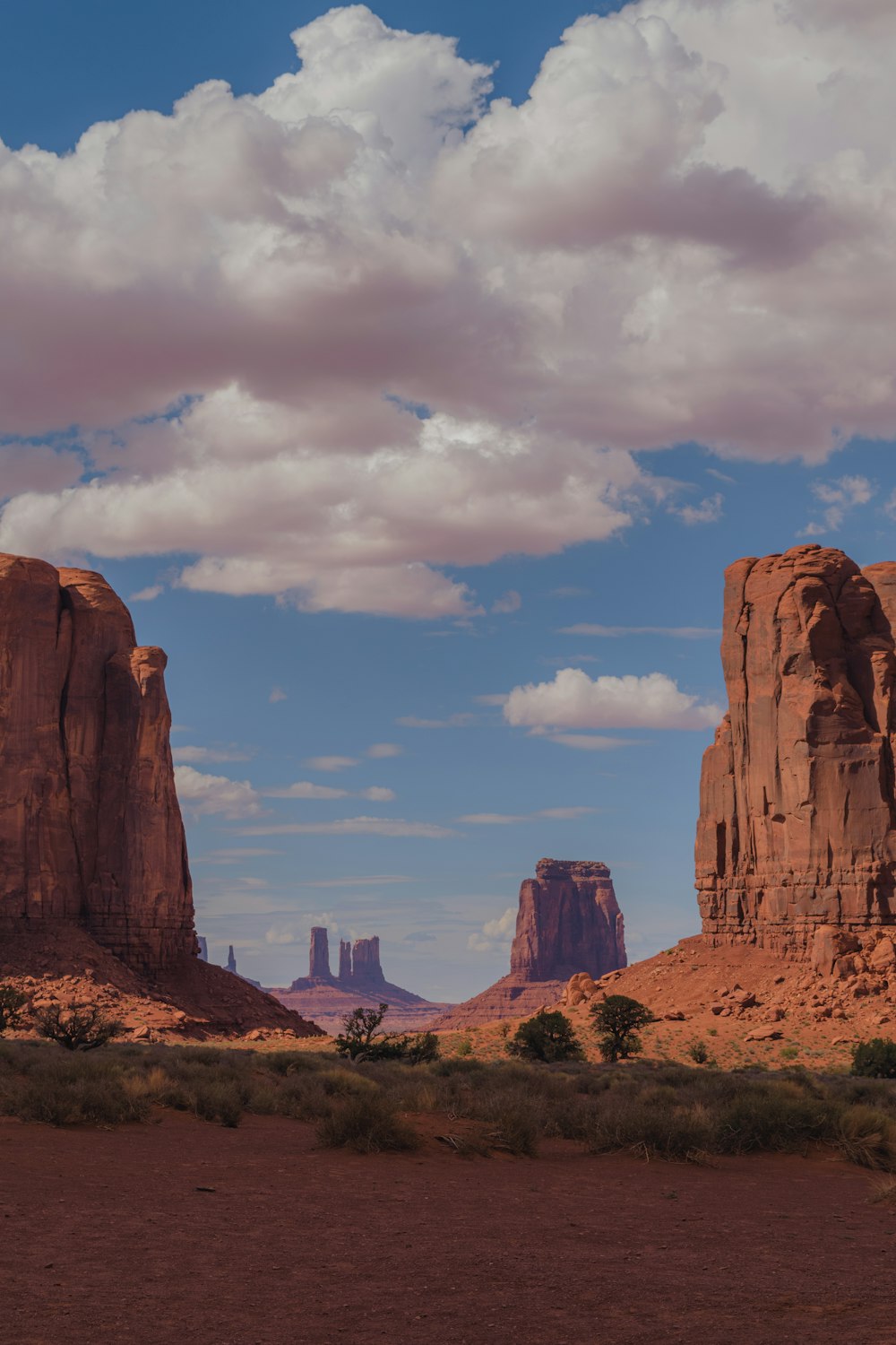 a desert landscape with rocks and a mountain in the background