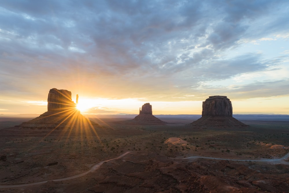 the sun is setting over the desert landscape