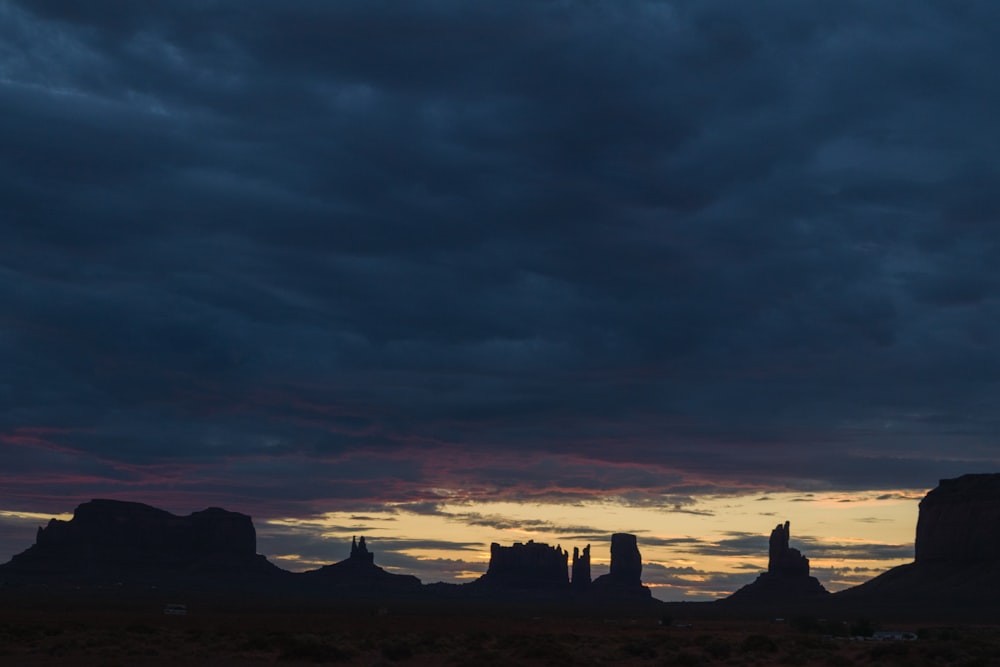 the sun is setting over the mountains in the desert