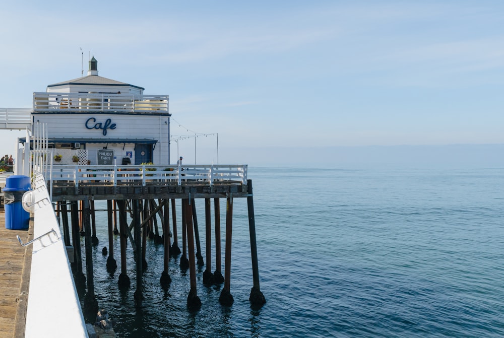 a pier with a cafe on it next to the ocean