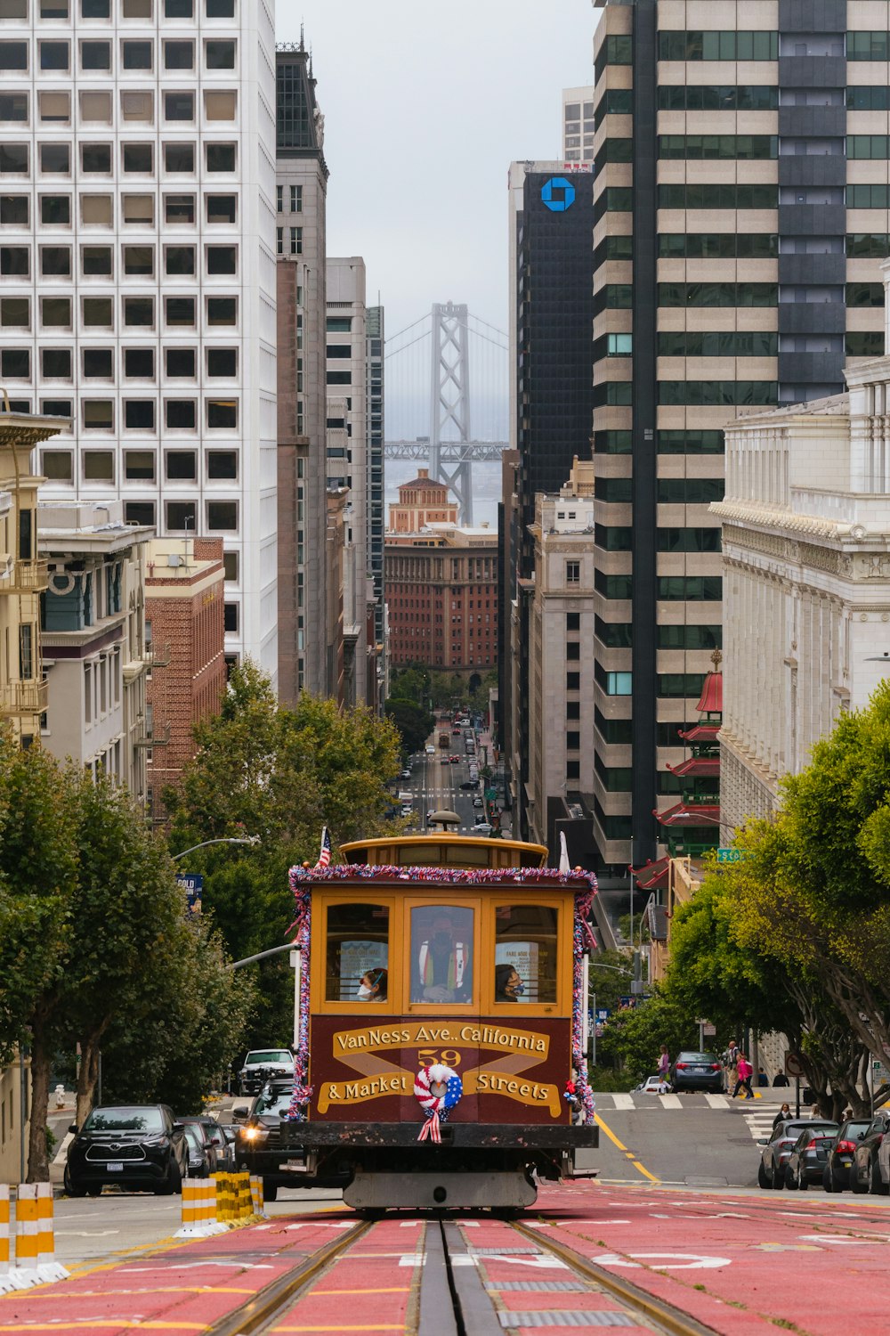 a trolley car traveling down a street next to tall buildings
