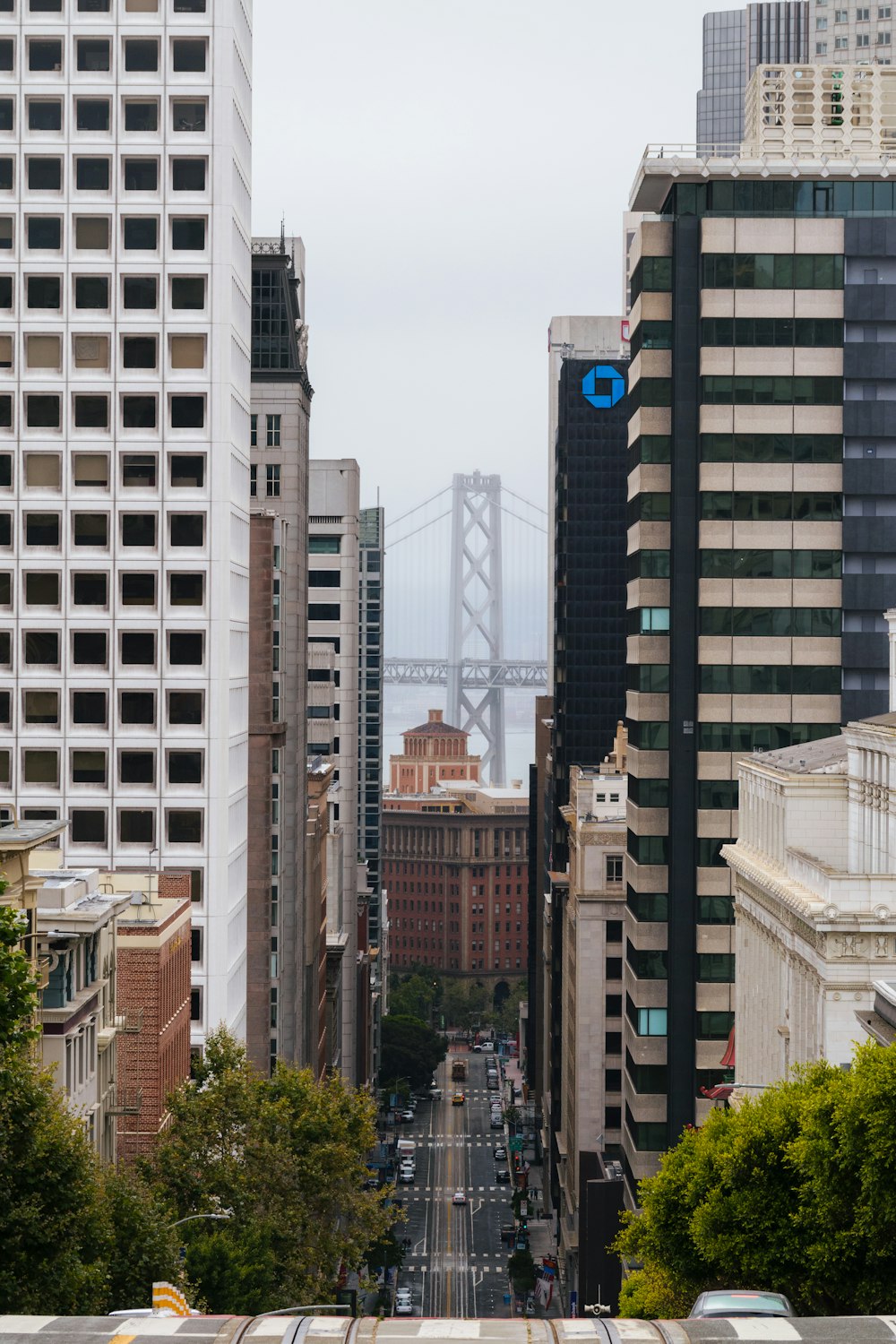 a view of a city street with a bridge in the background