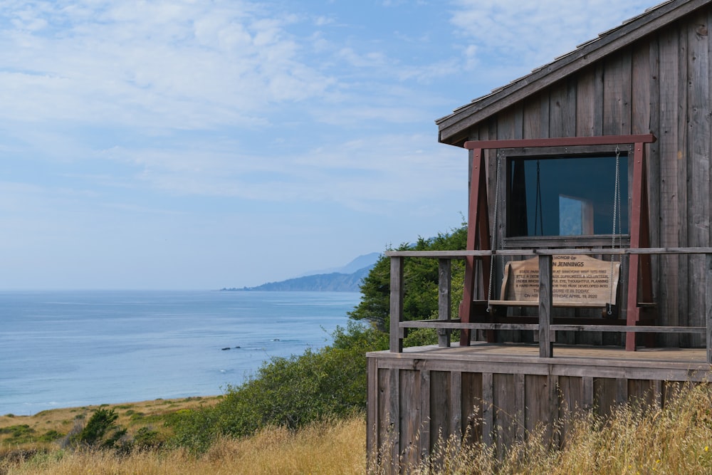 a wooden cabin with a balcony overlooking the ocean