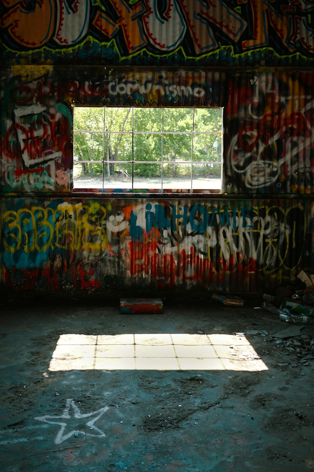 a room with graffiti on the walls and a window