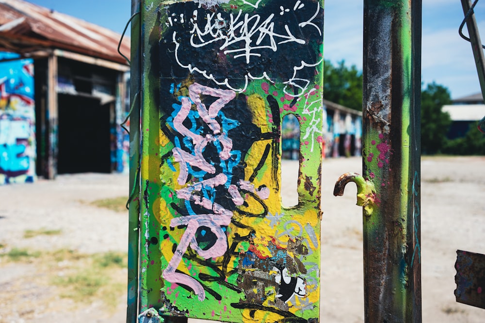 a metal pole with graffiti on it in front of a building