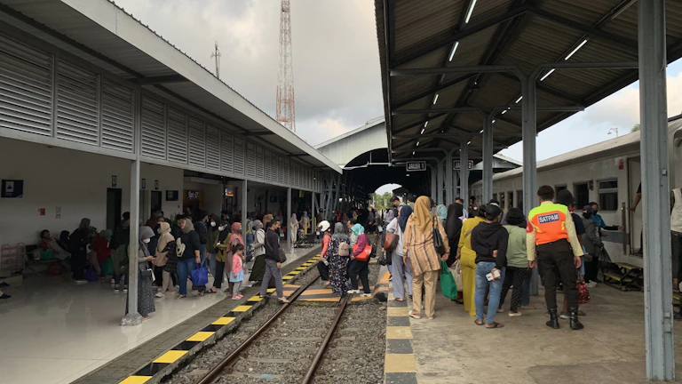 Volunteers assisting passengers at a busy transit station during peak hours
