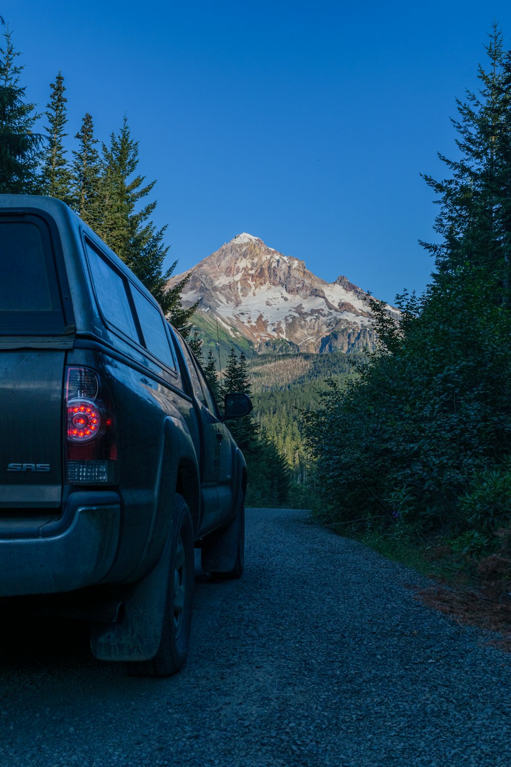 a truck parked on the side of a road in front of a mountain