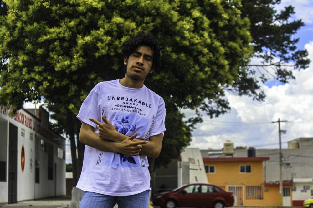 a man standing in the street with his arms crossed