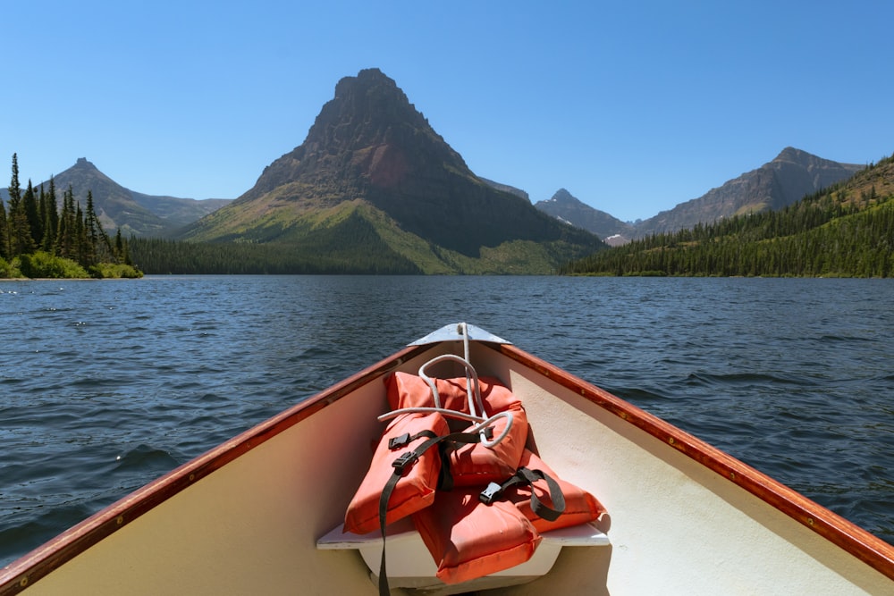 the bow of a boat on a lake with mountains in the background