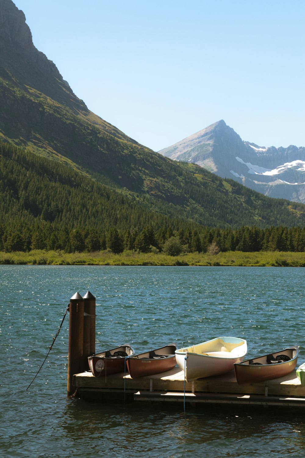 a boat tied up to a dock on a lake