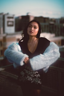 Evening shot of a city rooftop with a model wearing a statement Styleova coat against the skyline.