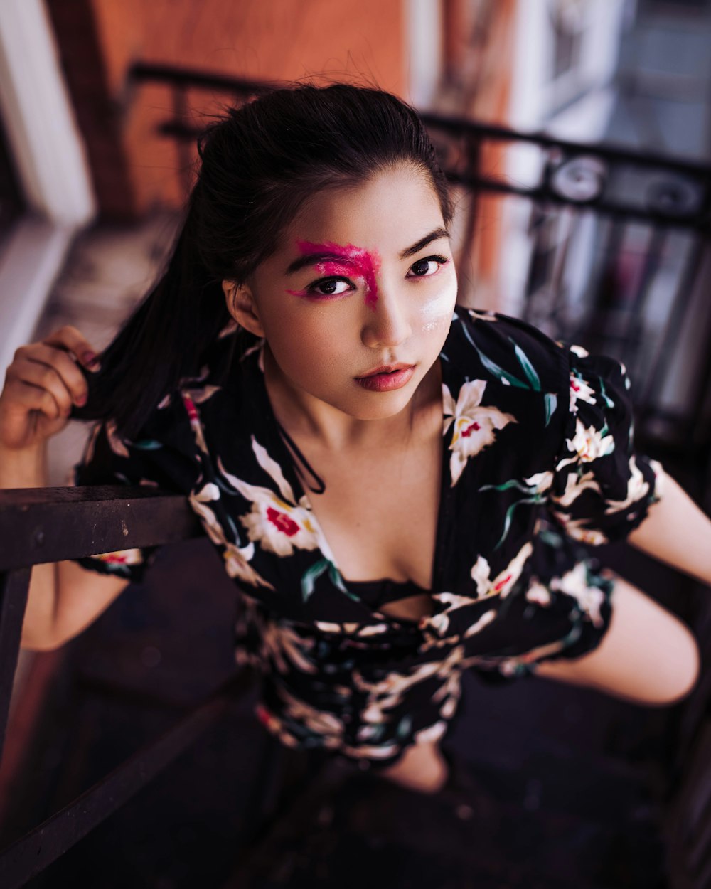 a woman with a flowered shirt and pink makeup