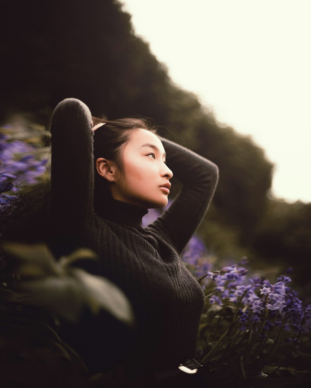 a woman is sitting in a field of flowers