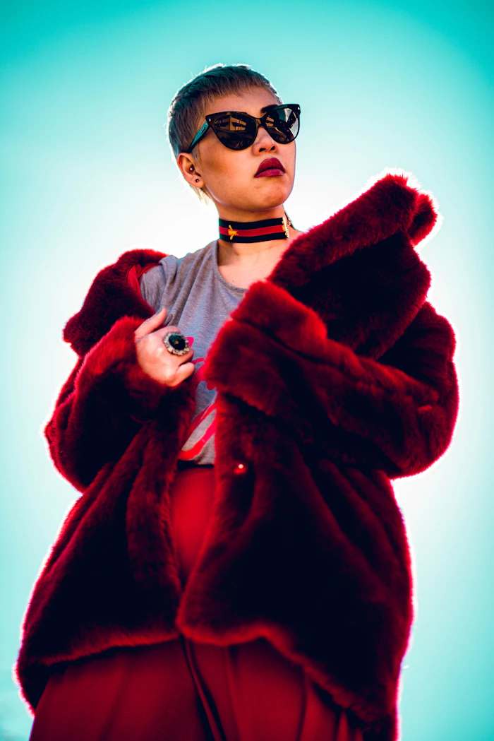 Model wearing oversized sunglasses and fur collar, Y2K editorial portrait