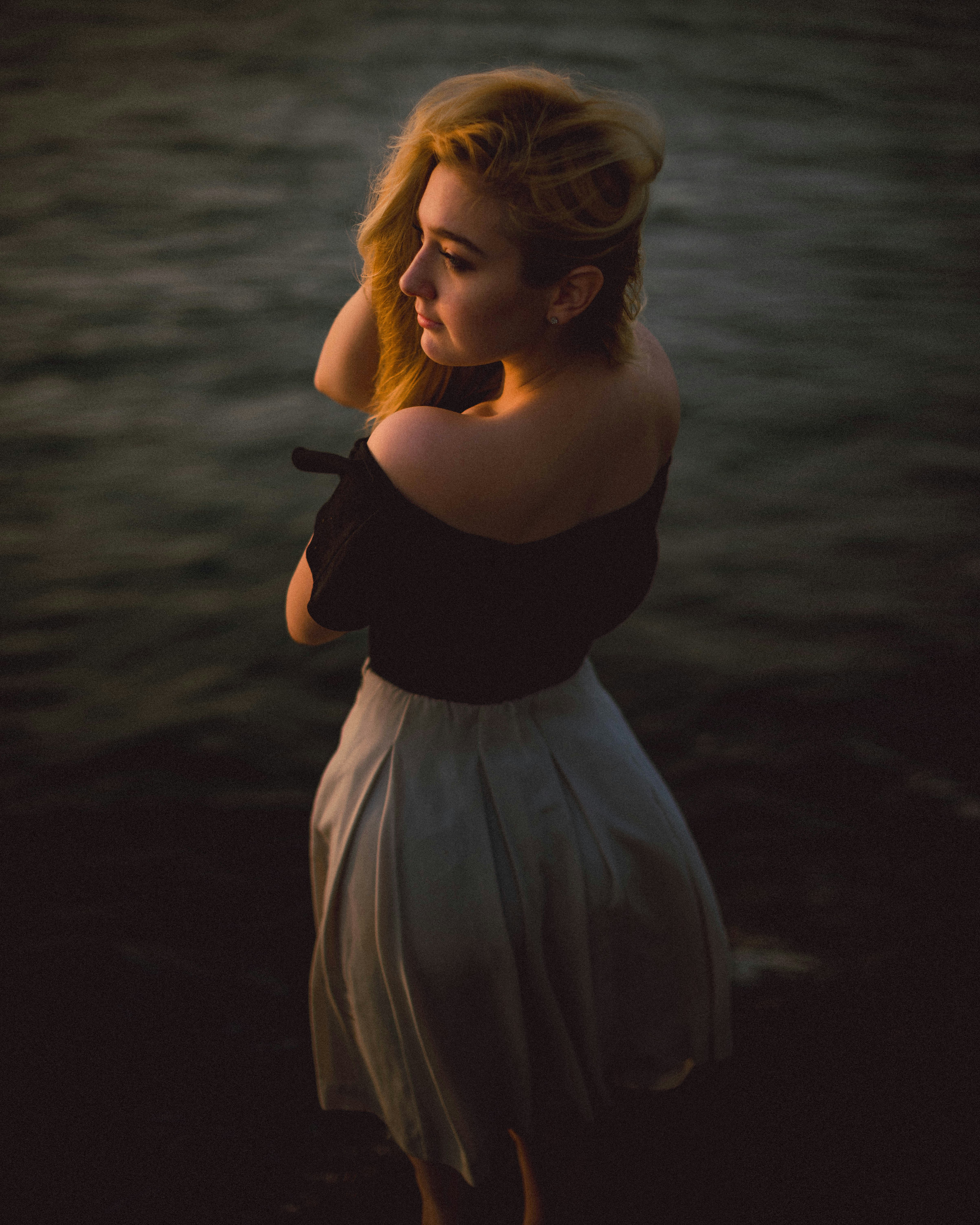 a woman in a black top and a white skirt