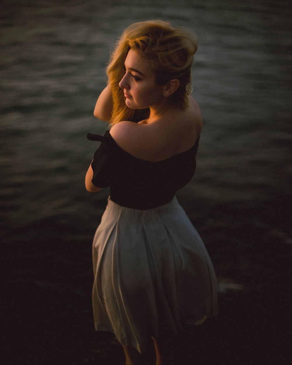 a woman in a black top and a white skirt