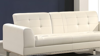 A modern, white, upholstered sofa with a minimalist design and tufted backrest sits in a room with a neutral color scheme. The background features a dark blue wall and contrasting white elements, creating a clean and contemporary aesthetic.