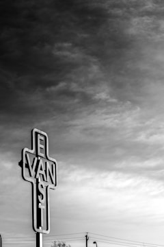 Black and white photo of a rainy Vancouver alley with vibrant blue text overlay.