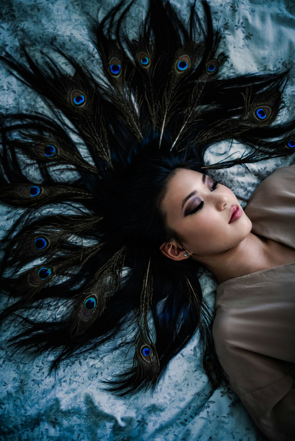 a woman laying on top of a bed covered in feathers