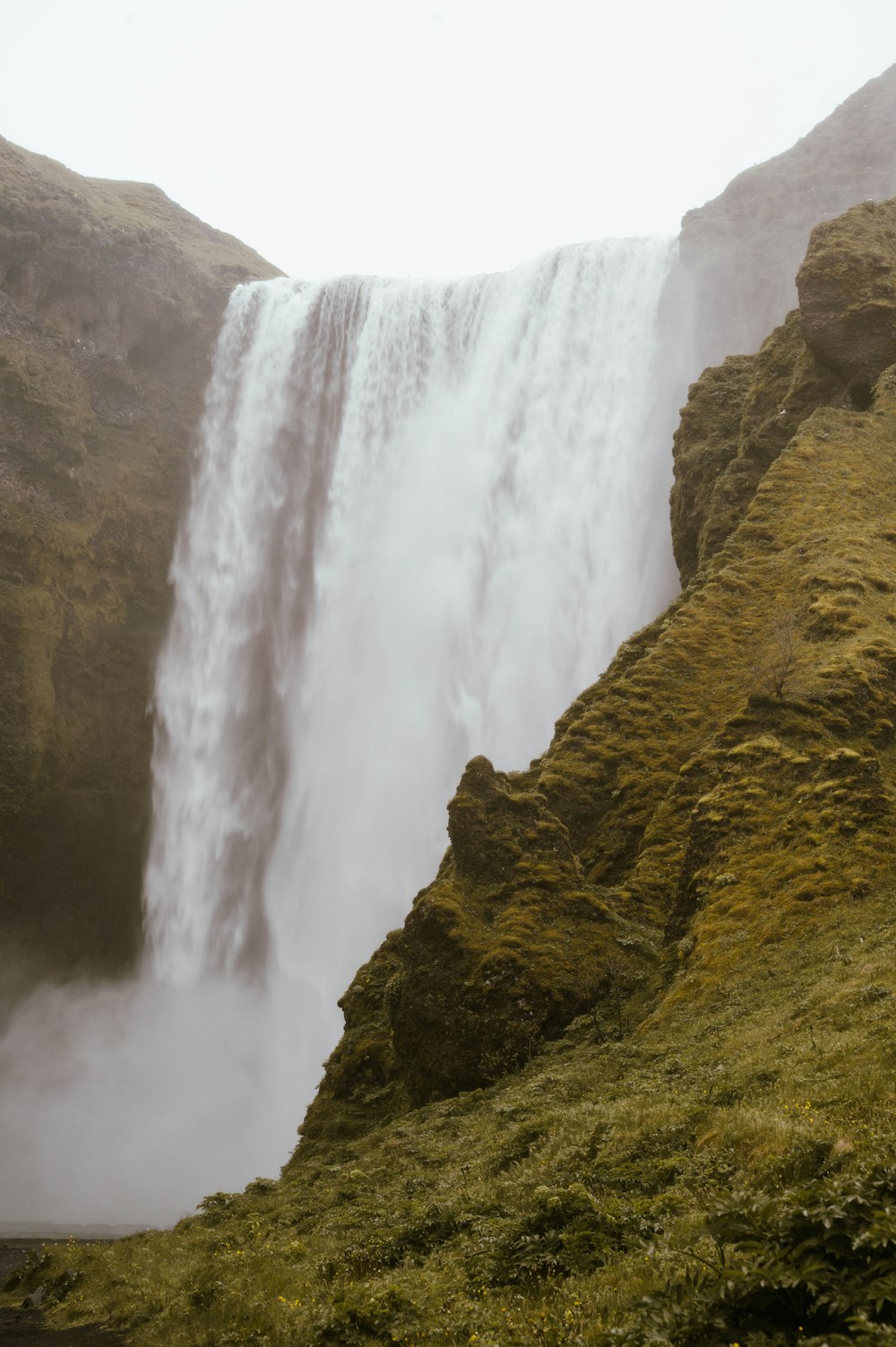 a large waterfall with a man standing on top of it