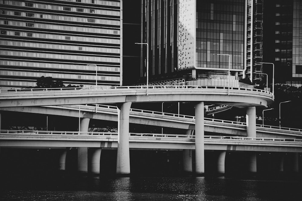 a black and white photo of a bridge over water