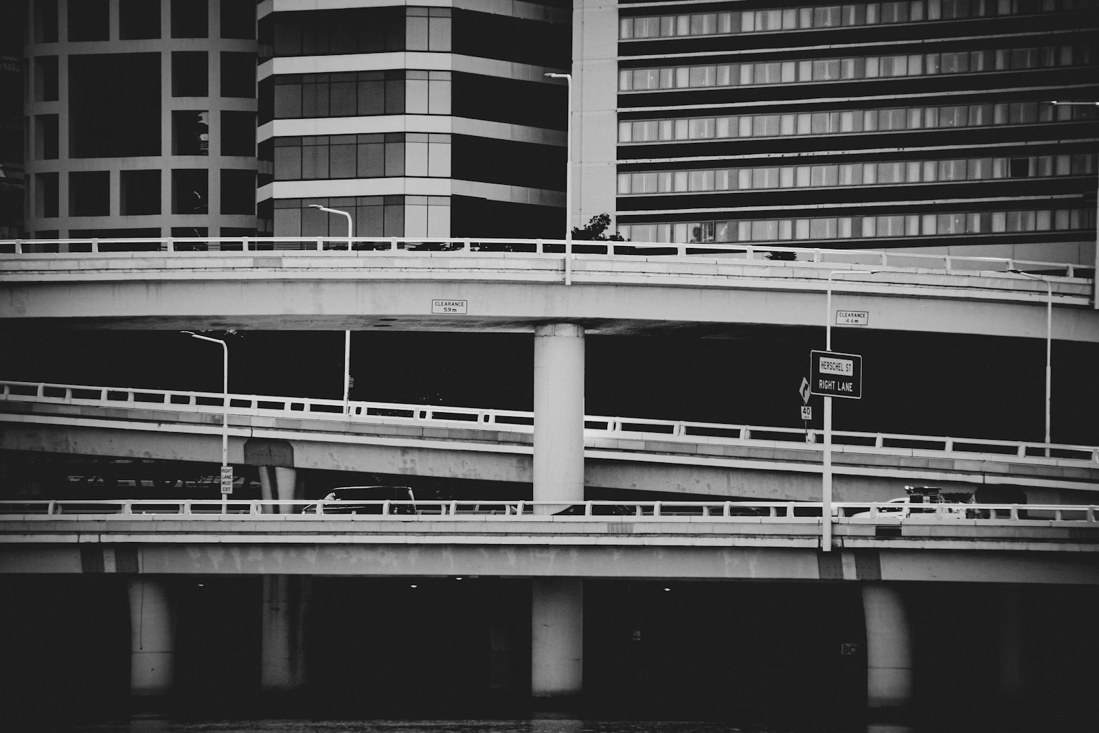 Black and white view of a bridge crossing the water in an Australian city