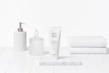 Close-up of polished chrome soap dispensers and toothbrush holders arranged neatly on a marble countertop