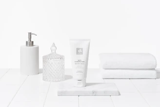 a softly lit, minimalistic arrangement of everyday essentials on a clean white surface