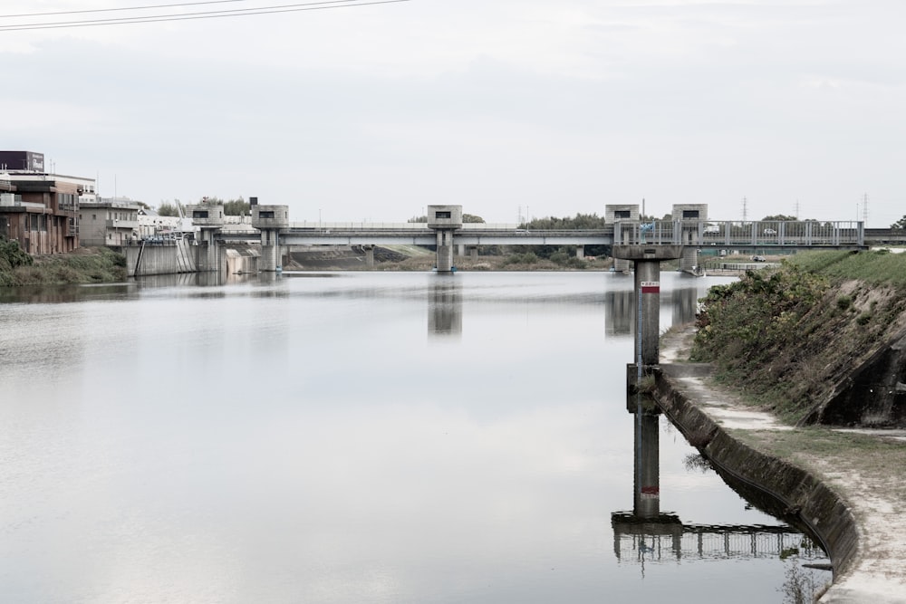 a body of water with a bridge in the background