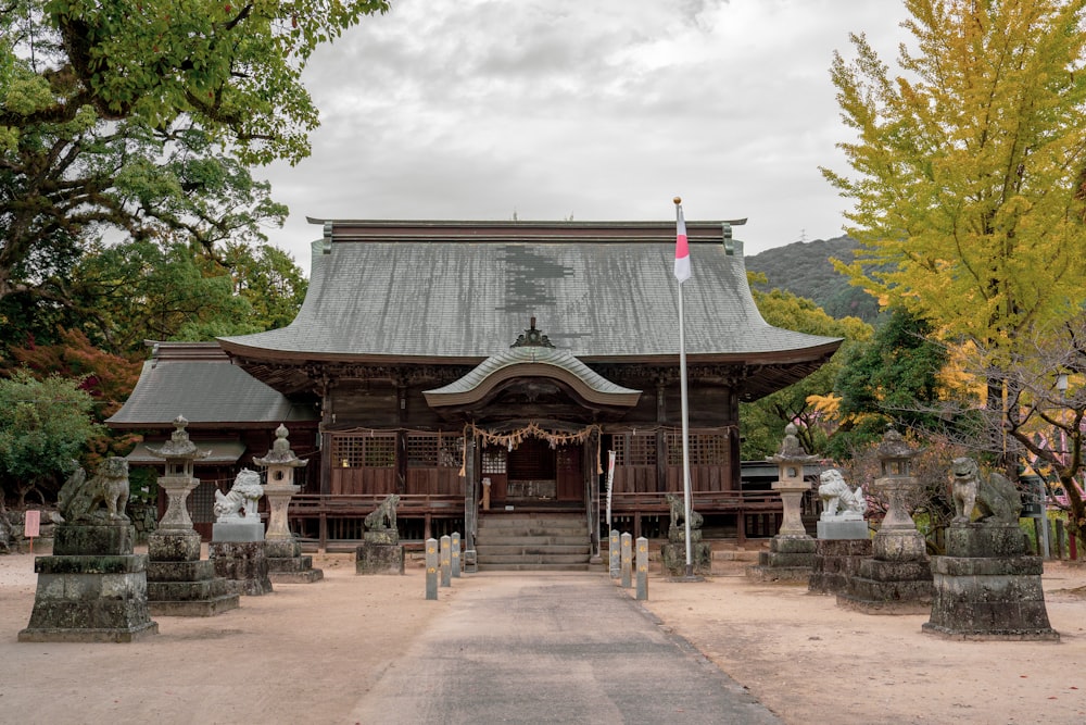 a wooden building with statues in front of it