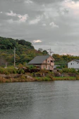 Wide-angle view of a sustainable coastal house with glass facades and a green living roof overlooking the Scottish sea.