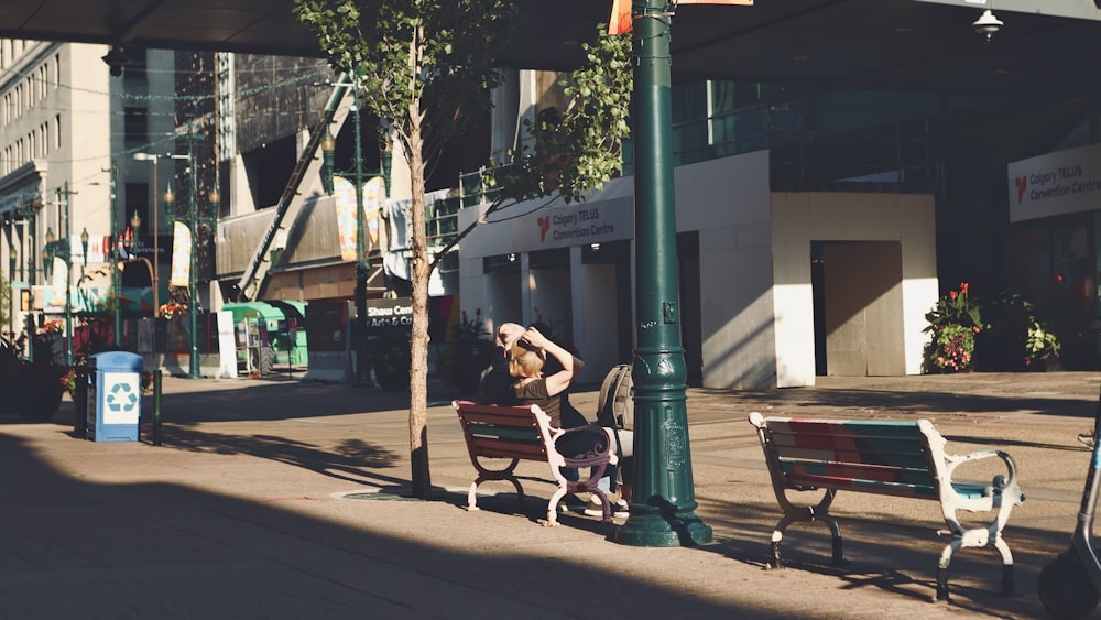 a woman sitting on a bench on a city street