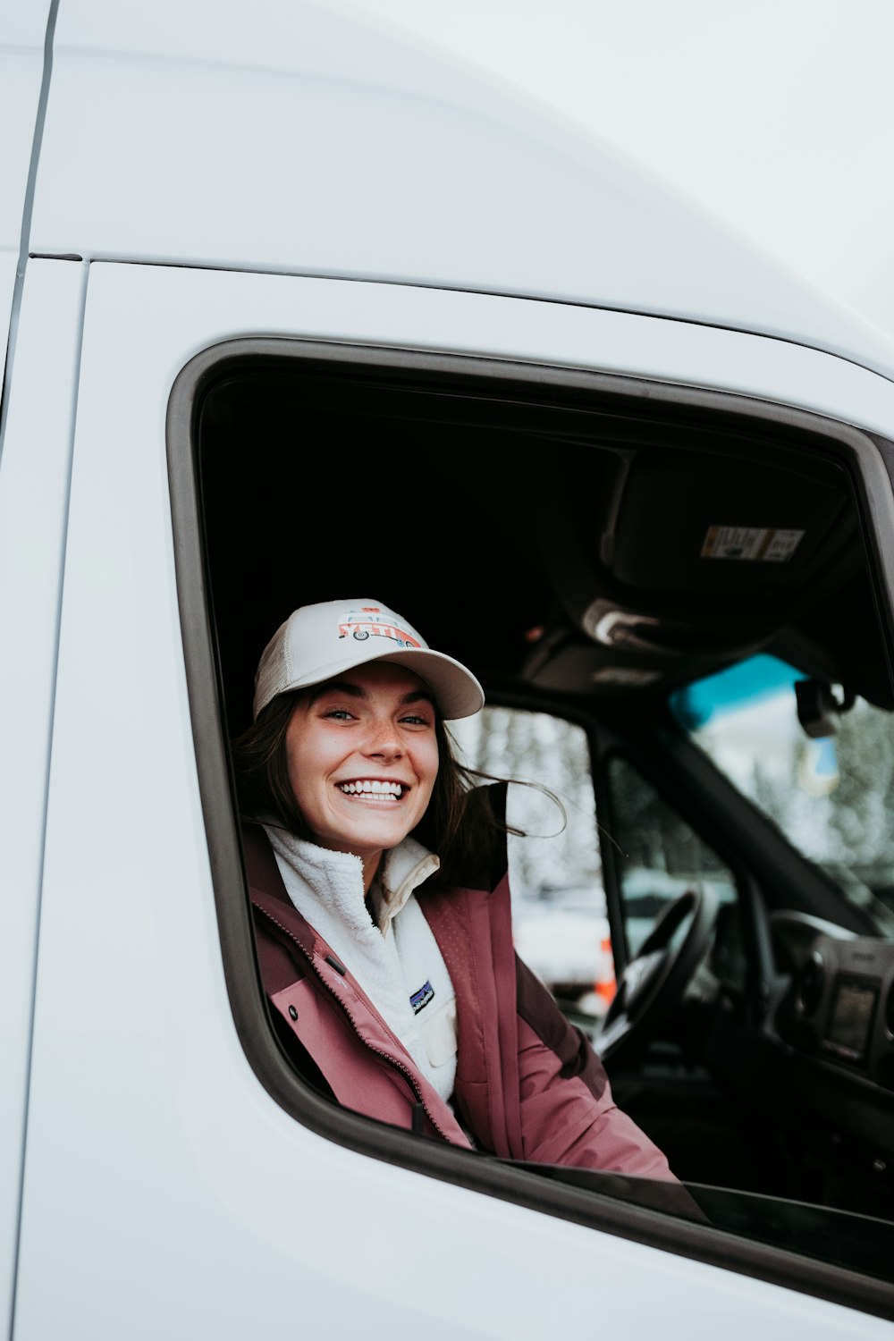 a woman sitting in the drivers seat of a truck