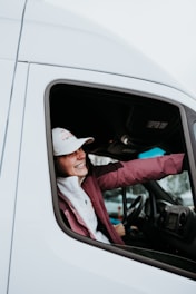 a woman sitting in the driver's seat of a white truck