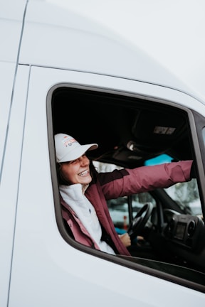 a woman sitting in the driver's seat of a white truck
