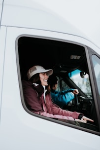 a man driving a truck with a woman in the driver seat