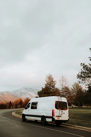 a white van driving down a curvy road