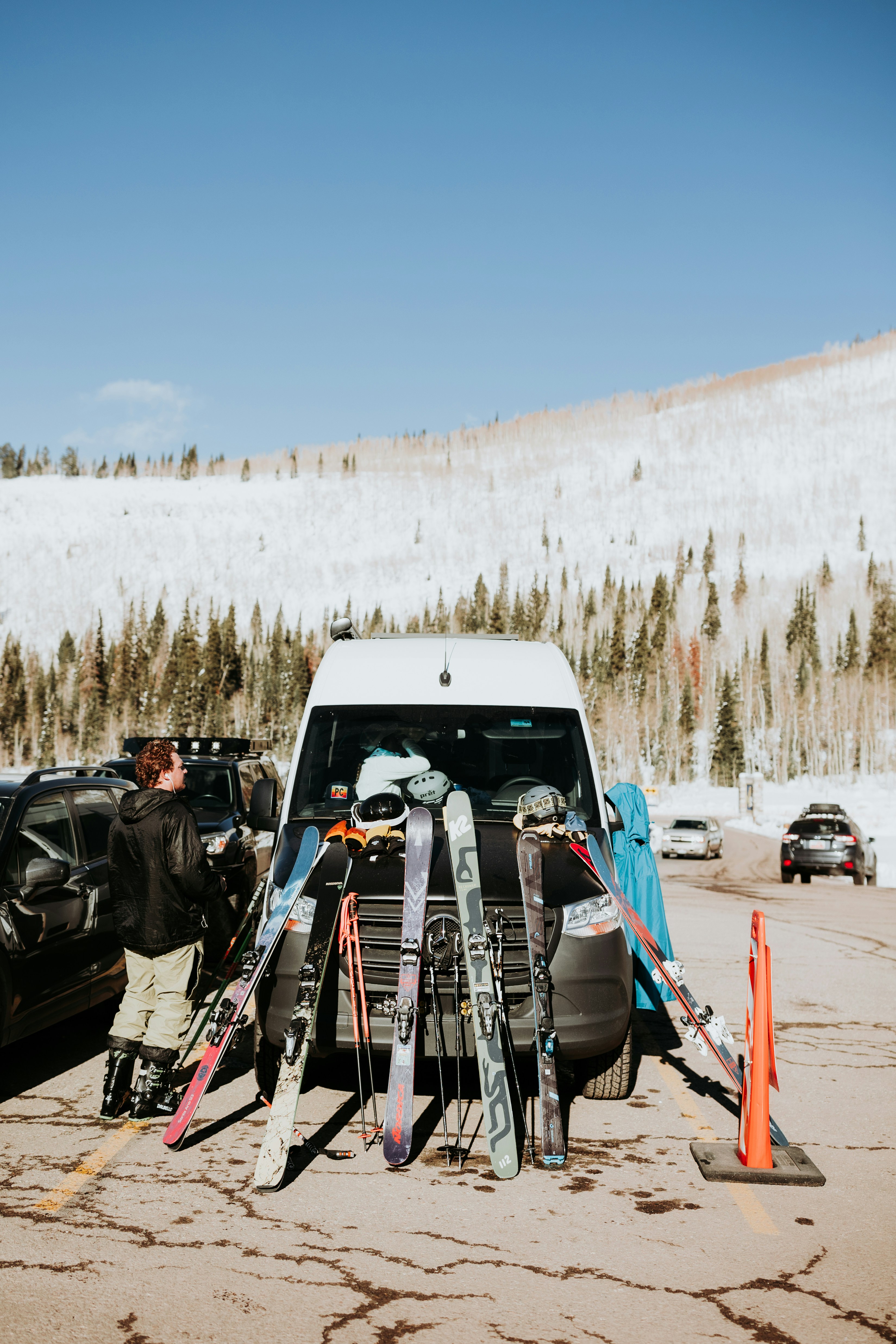 A car is parked in a parking lot with skis on it photo – Free Mountains ...