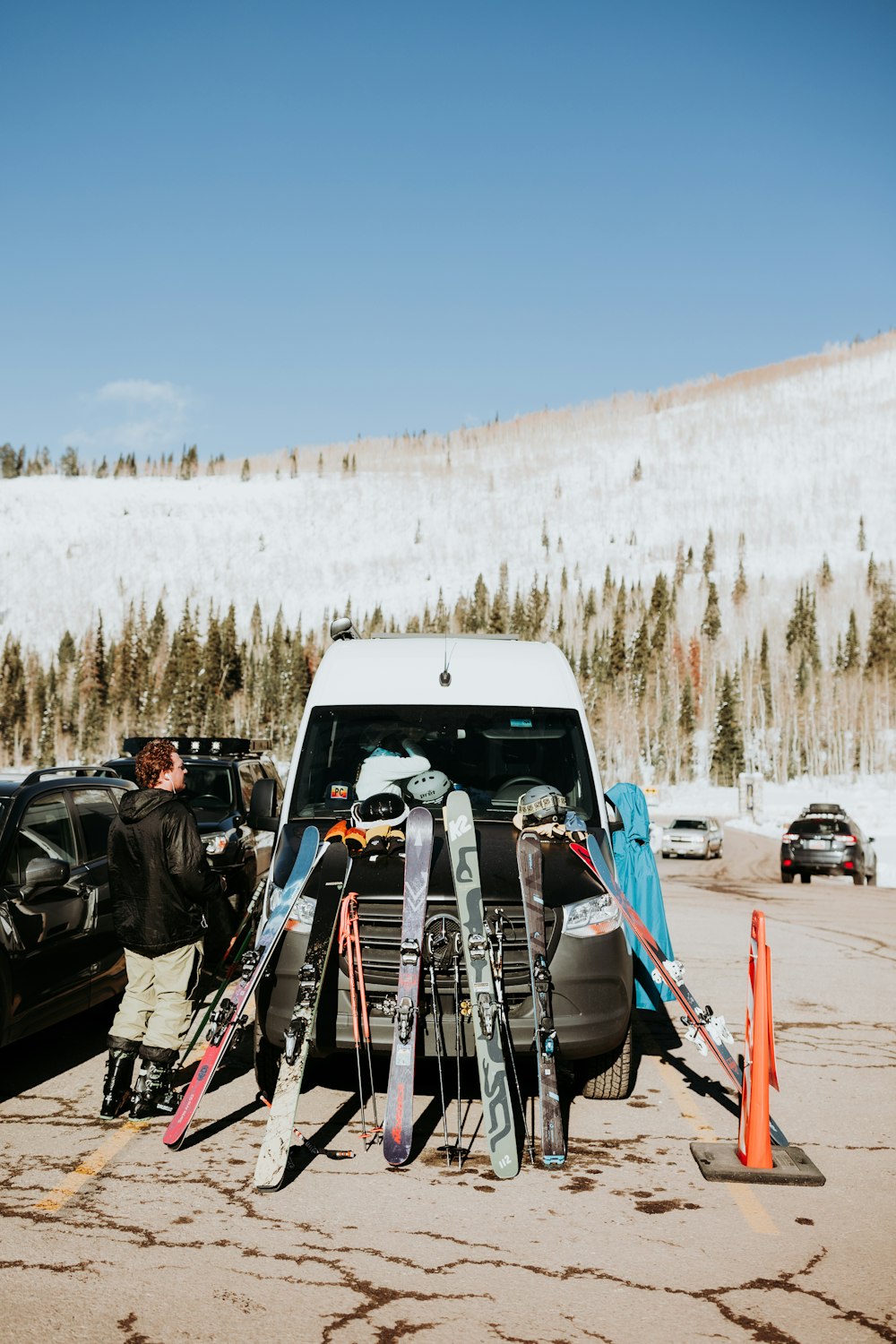 a car is parked in a parking lot with skis on it